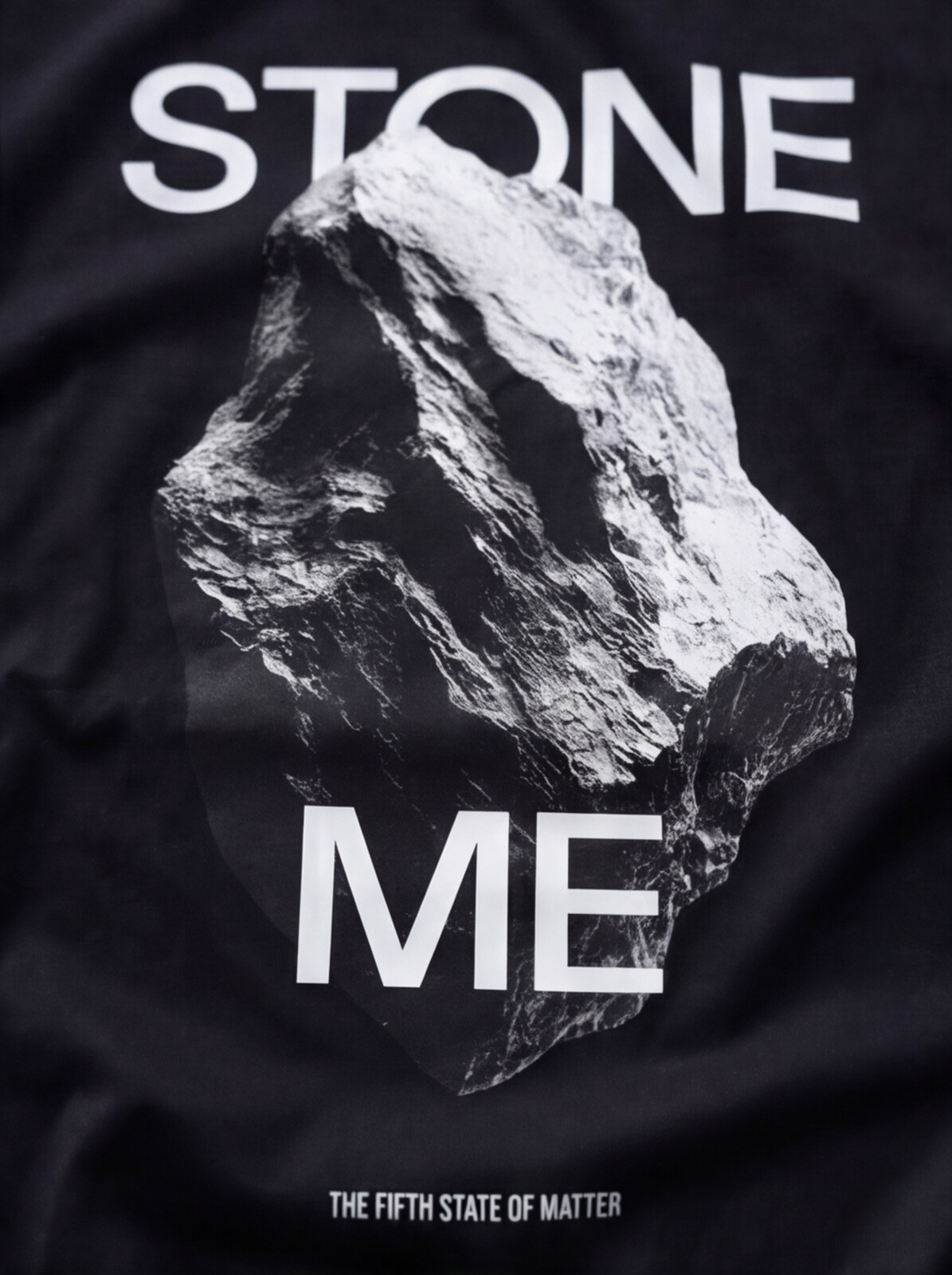 STONE ME tee — close-up of the rock print on black cotton